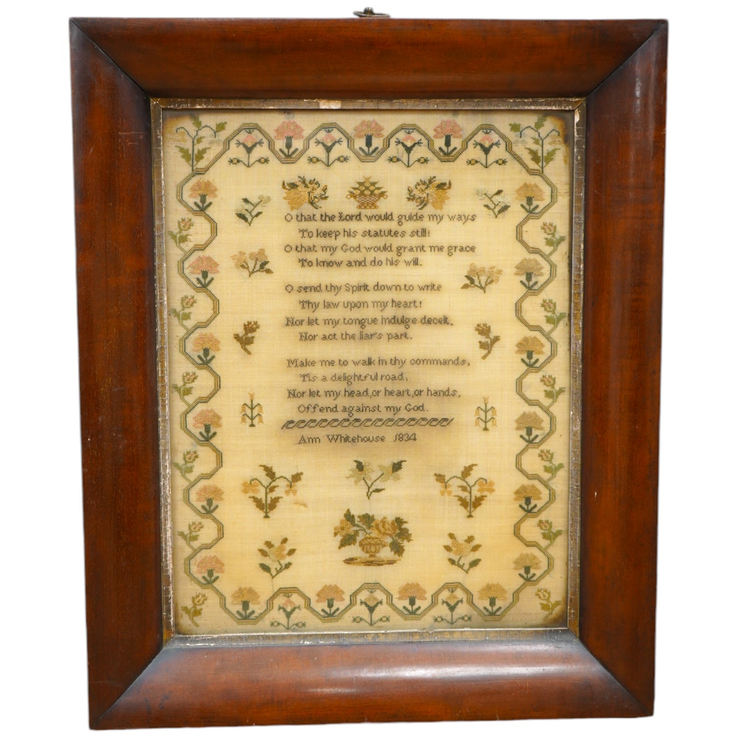 A wide mahogany framed sampler by Ann Whitehouse dated 1834, worked in coloured silks on a fine linen ground, in small stitches, bordered with a geometric stylistic vining pattern, set with a central verse, above her nam